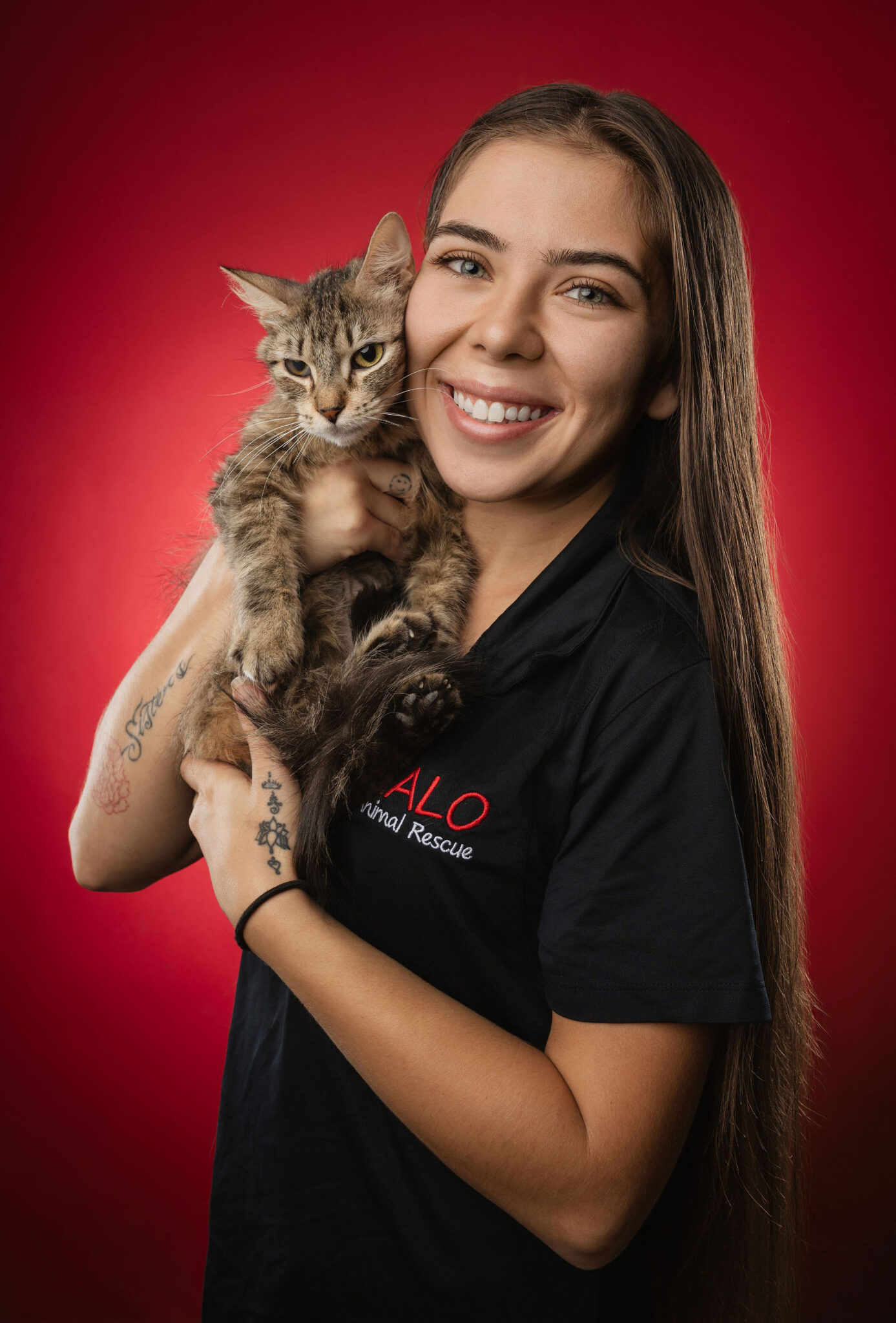 Mackenzie Hogan, a staff member, stands holding a cat